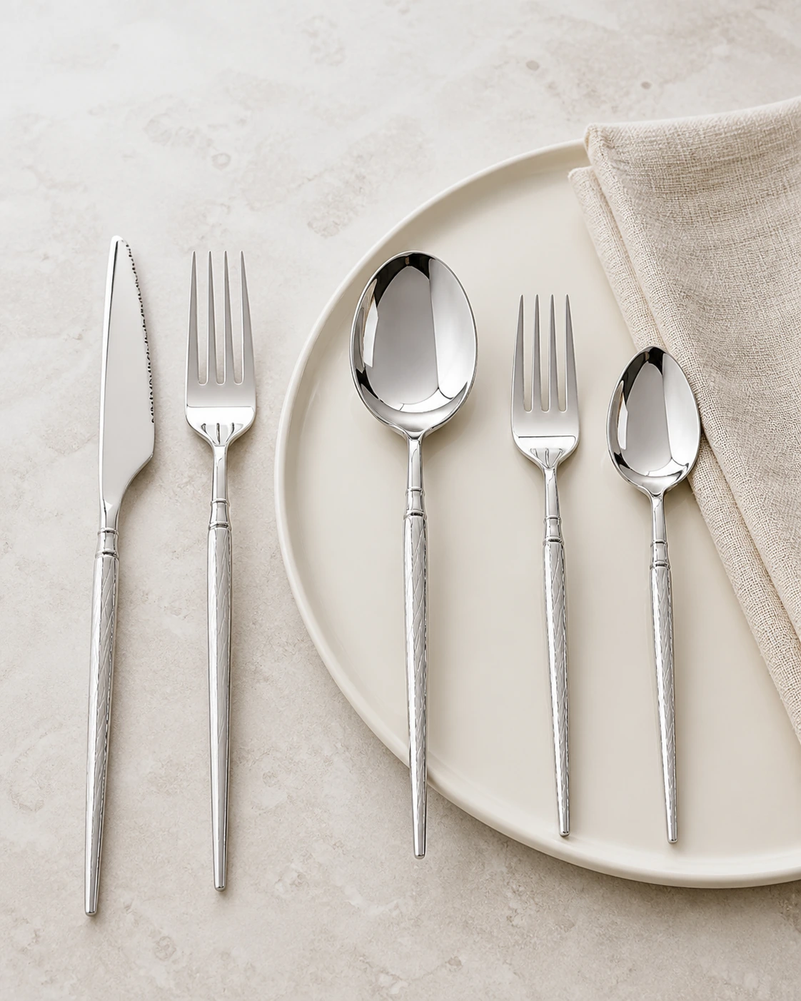 Lattice silver flatware arranged around an ivory place setting