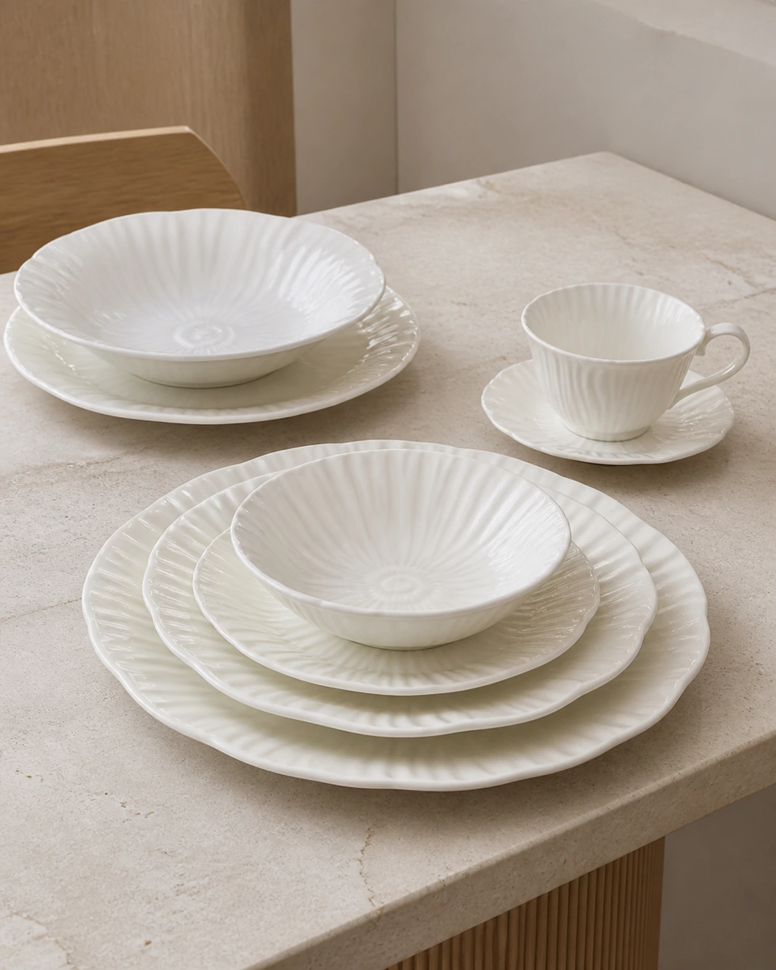 Petale ivory fluted dinnerware arranged on a pale stone table