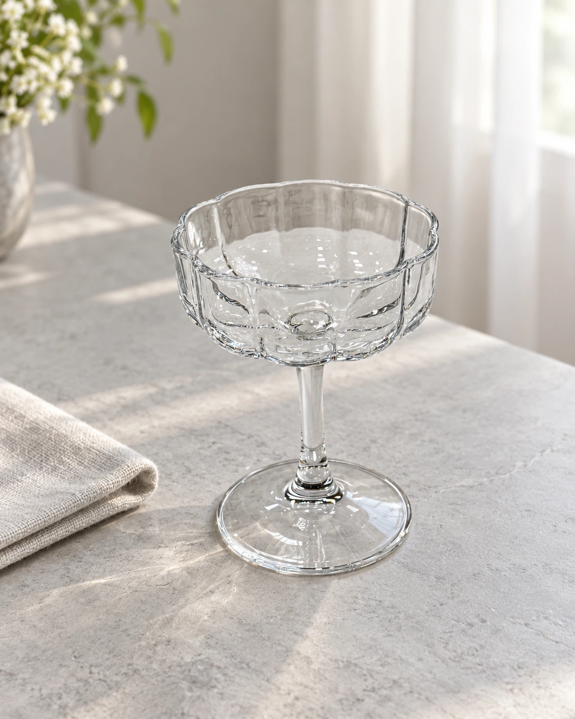 Clear glass coupe with a fluted bowl in a bright interior