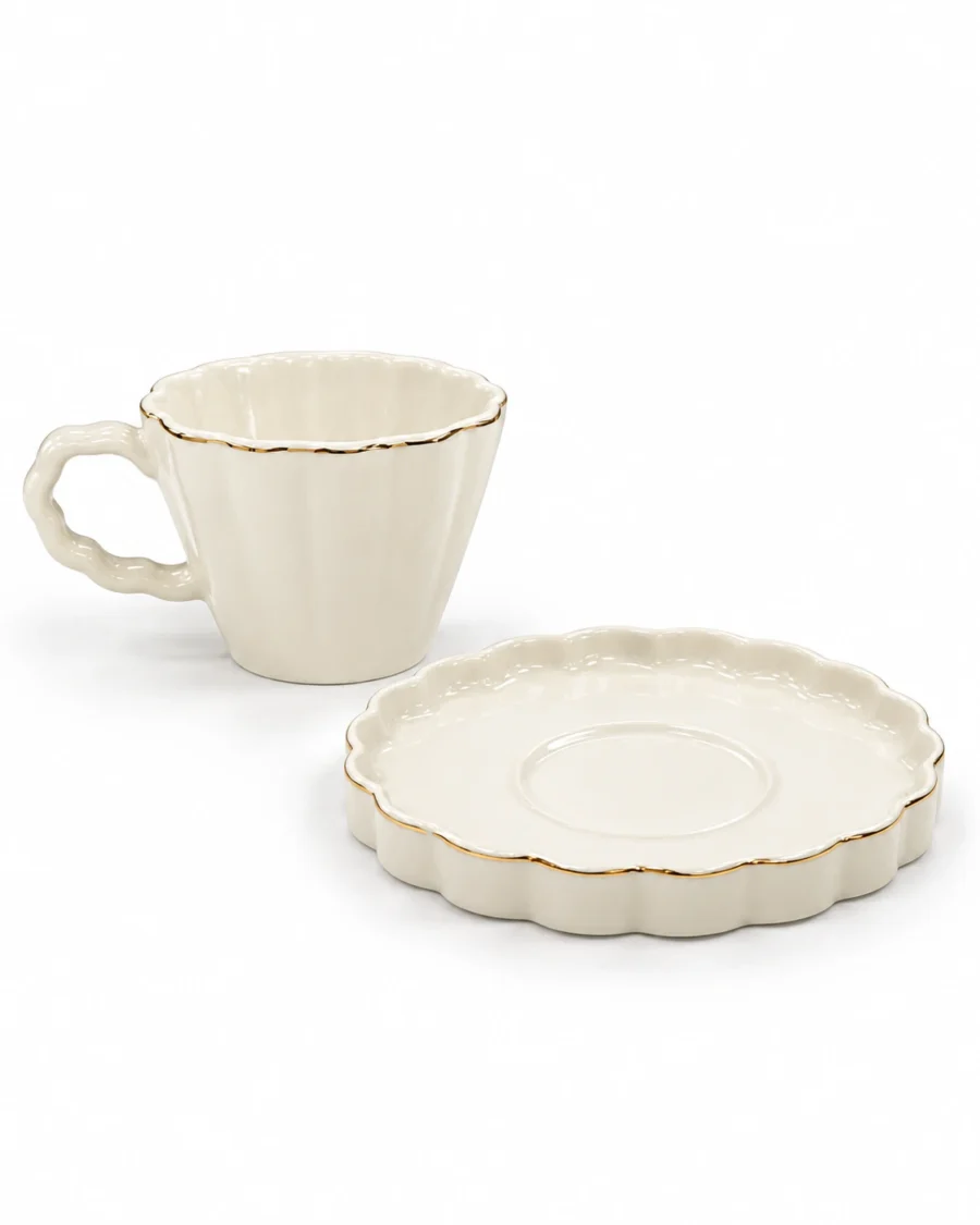 White porcelain cup and saucer with scalloped edges and gold-coloured trim
