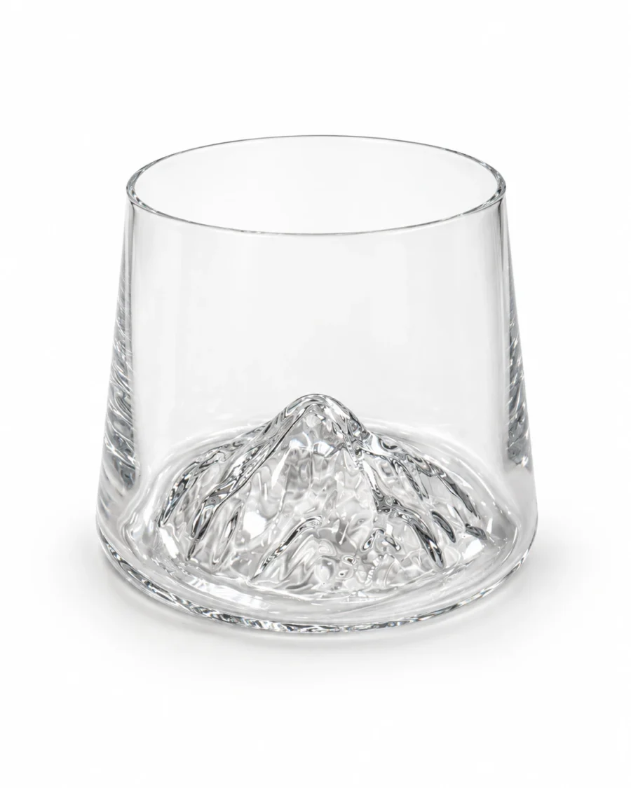Clear glass tumbler with a raised mountain-shaped base