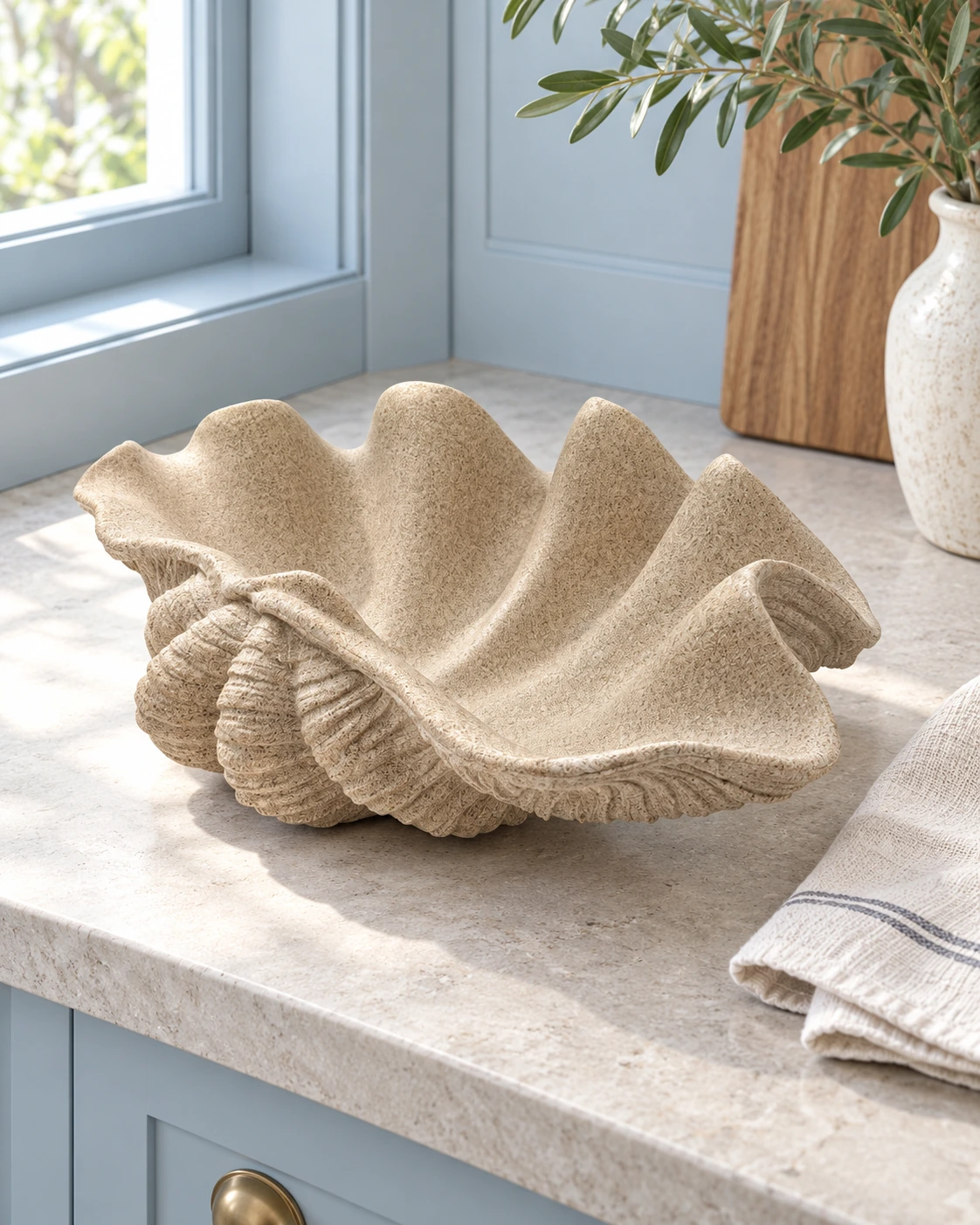 Sand-coloured polyresin vase with a shell-shaped silhouette in a bright interior