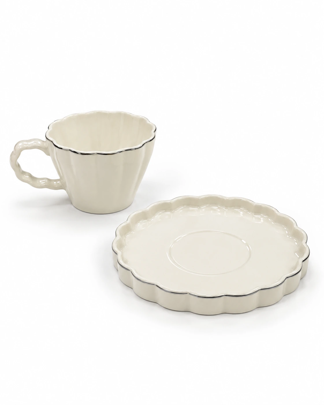 White porcelain cup and saucer with scalloped edges and silver-coloured trim