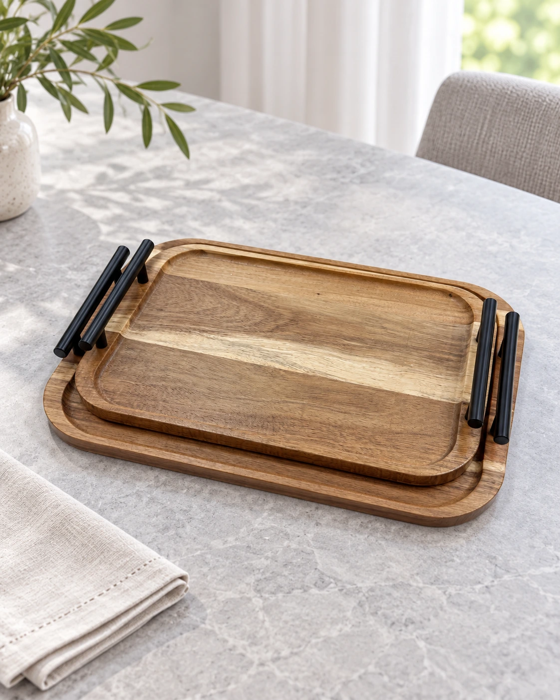 Two rectangular wood trays with black handles in a bright interior